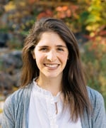 Headshot of Talie Sternbach. Standing in front of foliage.